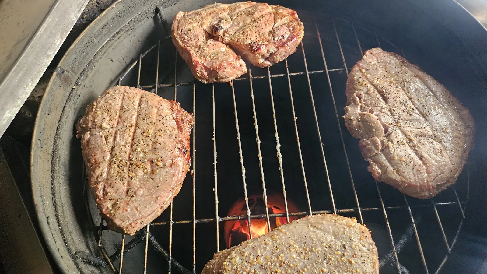 Cuatro cortes sobre la parrilla con la brasa encendida debajo