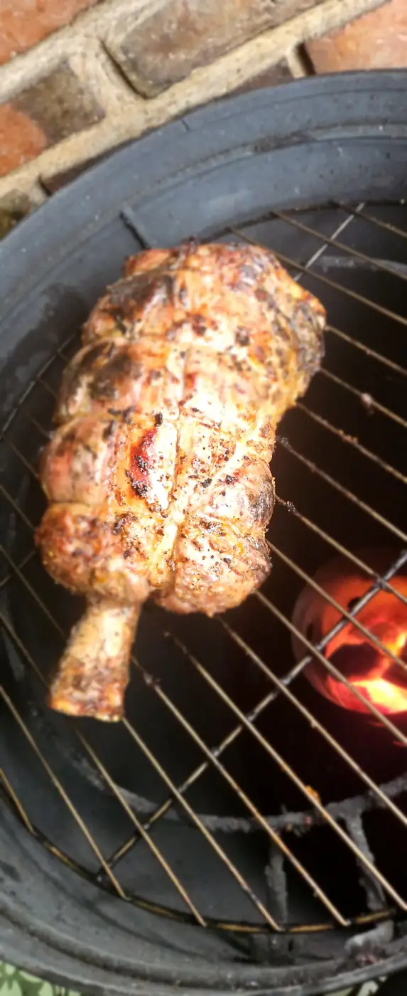 Pieza amarrada sobre la parrilla circular con carbón encendido