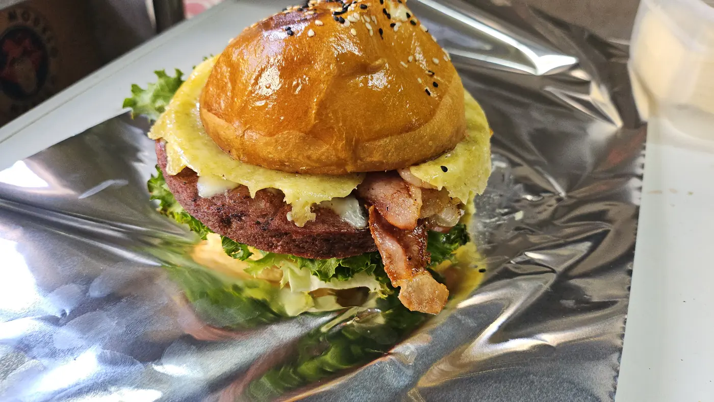 Hamburguesa con tocino y piña sobre papel aluminio