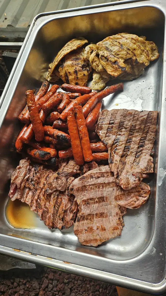 Charola de parrillada mixta con arrachera, chorizo y pollo recién salidos de la parrilla